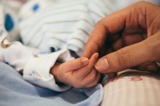 person holding baby's index finger